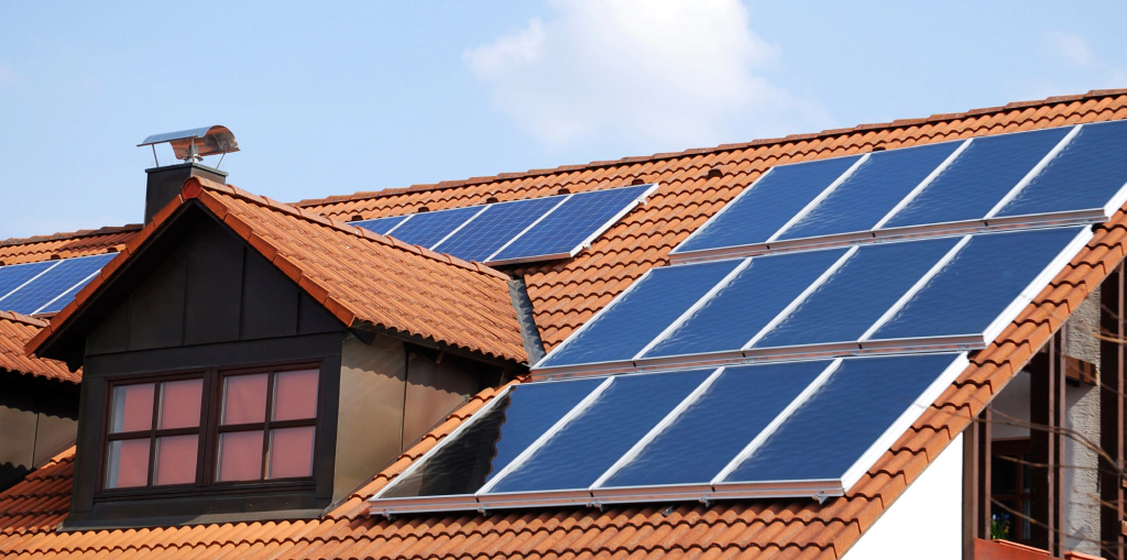 white house with a light brown orange roofing with some solar panel installaltions